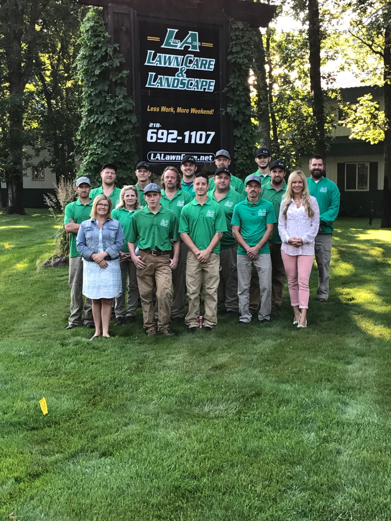 LA Lawn Care & Landscape team photo in front of company sign